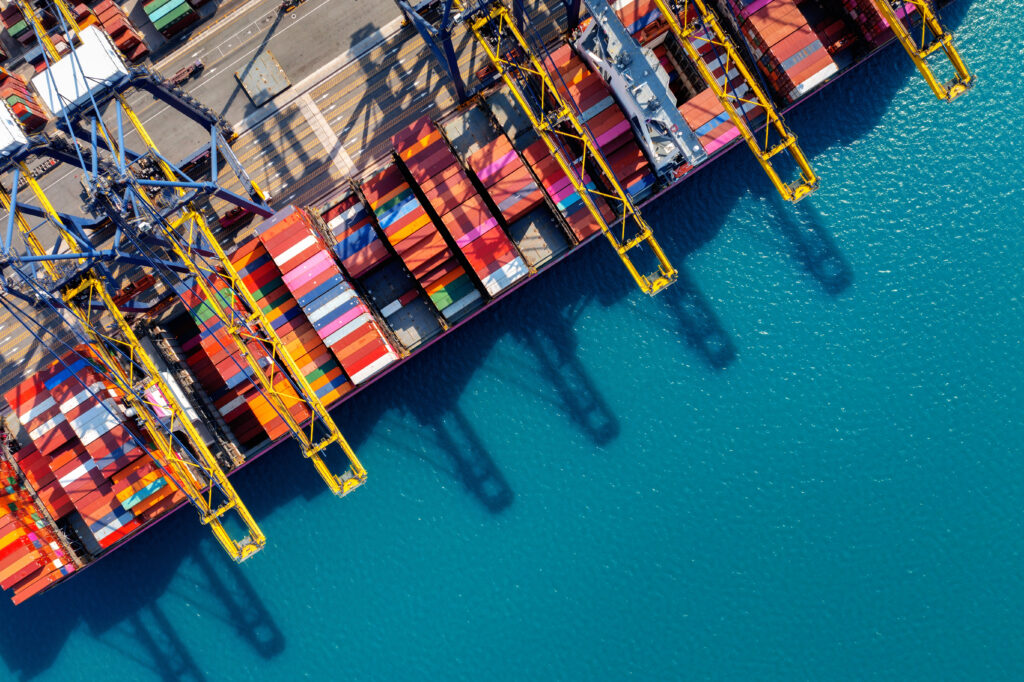 aerial view of cargo ship and cargo container in harbor.