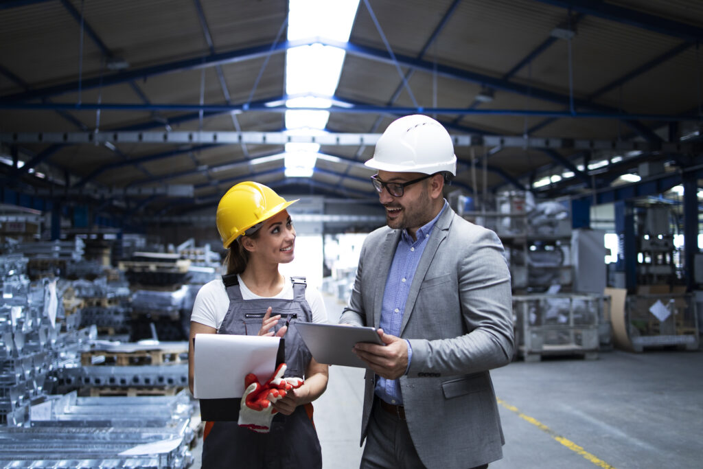 manager supervisor and worker discussing about production results and new strategy in factory industrial hall.