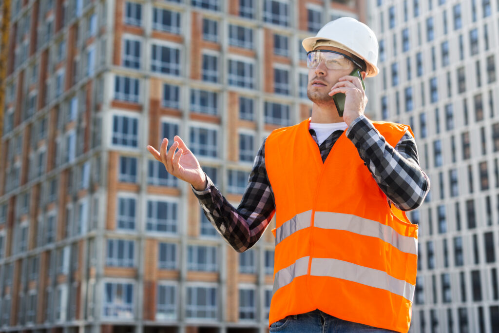 medium shot side view construction engineer talking phone
